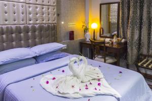 een hotelkamer met een bed met een witte handdoek bij Newtown Inn in Hulhumale