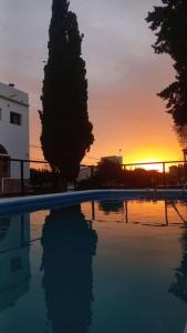 una piscina con il tramonto sullo sfondo di Holâ Hotel a La Falda