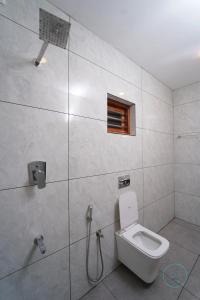 a bathroom with a toilet and a shower at Le Eden Resort in Sultan Bathery