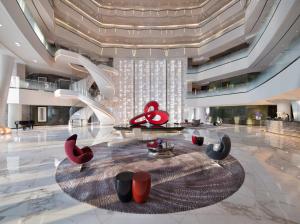 una hall con tavolo e sedie rosse e nere di Four Seasons Hotel Guangzhou a Canton