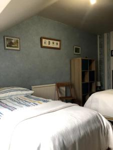 ein Schlafzimmer mit 2 Betten und einem Stuhl in einem Zimmer in der Unterkunft La maison de Jeanne in Santenay