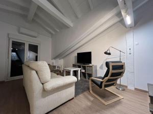 a living room with a chair and a television at Loft en el casco histórico in Laredo