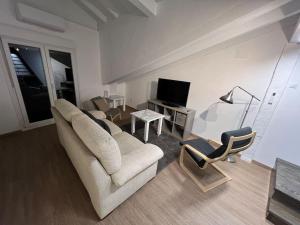 a living room with a couch and a tv and a chair at Loft en el casco histórico in Laredo