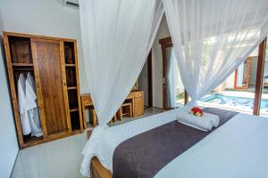 um quarto com uma cama e uma janela com uma piscina em Karang Island Villa em Nusa Lembongan