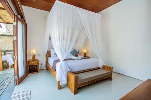 um quarto com uma cama e uma rede mosquiteira em Karang Island Villa em Nusa Lembongan