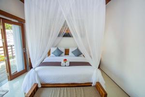 um quarto com uma cama de dossel em Karang Island Villa em Nusa Lembongan