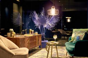 a living room with two chairs and a table with a table at Van der Valk Hotel Brussels Airport in Diegem