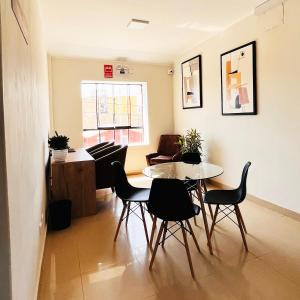 a living room with a table and chairs and a piano at Rua Hoteles Talara in Talara