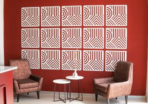 two chairs and a table in front of a wall at Rua Hoteles Talara in Talara