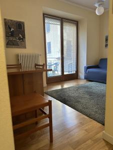 a living room with a blue couch and a window at Apartment BelLenno in Lenno