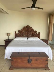 um quarto com uma cama grande e uma cabeceira em madeira em Alojamientos Alexa em Sayulita