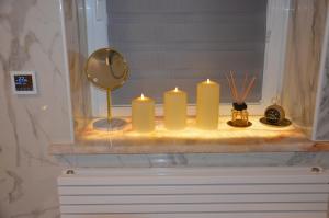 a group of candles sitting on a shelf in a bathroom at Gemütliche Apartment Lucky und Lucky de Luxe in Bremerhaven