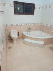 a bathroom with a tub and a toilet at Bondi Beach Resort in Karachi