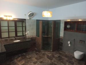 a bathroom with a shower and a sink and a toilet at Bondi Beach Resort in Karachi