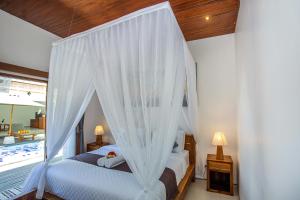 um quarto com uma cama com rede mosquiteira em Karang Island Villa em Nusa Lembongan