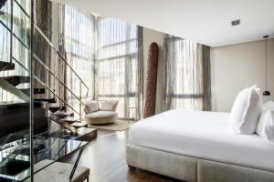 una camera con letto e una scala in vetro di Hotel Urban,a Member of Design Hotels a Madrid