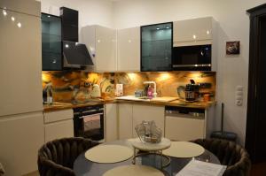 a kitchen with two tables and a kitchen with white cabinets at Gemütliche Apartment Lucky und Lucky de Luxe in Bremerhaven