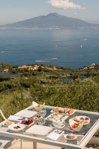 una mesa con comida y vistas al océano en Villa Eliana, en Sorrento