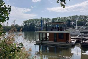 um pequeno barco está ancorado na água em Riverboat-Rhein-Main Ferienloft em Wiesbaden