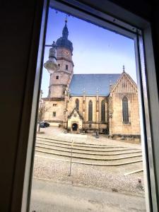 uma janela com vista para uma igreja com uma torre de relógio em Altstadtblick Altenburg em Altenburg