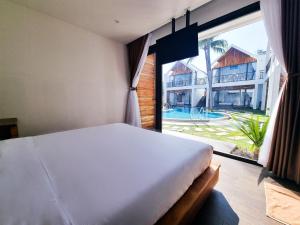 ムイネーにあるTuong Vy Boutique Hotel Mui Neのベッドルーム1室(ベッド1台、大きな窓付)