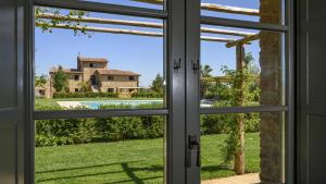 ein offenes Fenster mit Blick auf ein Haus in der Unterkunft Agriturismo Merigge Wellness & Spa Montepulciano in Montepulciano