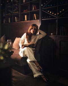 a woman sitting on a bed in a room at Royal Park Hotel & Apartments in Bansko