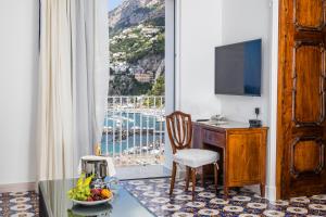 Pokój z biurkiem i oknem z widokiem na okolicę. w obiekcie Hotel Marina Riviera w Amalfi