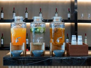 tres frascos de vidrio llenos de diferentes tipos de bebidas en Park Inn by Radisson Chengdu Sihe Metro Station Xinchuan, en Chengdú