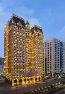 een groot gebouw met lichten aan in een stad bij Royal Rose Abu Dhabi, a Curio Collection by Hilton Affiliated Hotel in Abu Dhabi