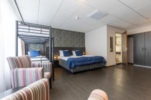 une chambre d'hôtel avec un lit et deux chaises dans l'établissement City Hotel de Jonge, à Assen