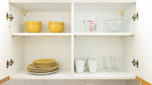 a cabinet filled with plates and bowls and glasses at Charmstay Swiss Cottage in London