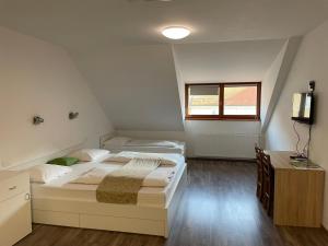 a bedroom with two beds and a desk and a window at Guesthouse Stari Mayr in Kranj