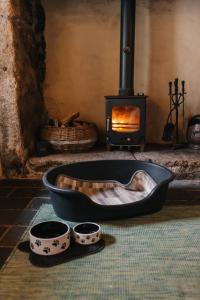 una chimenea con dos tazones y una sartén frente a ella en Kitts Cottage Redruth, en Redruth