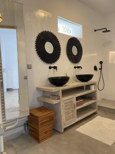 a bathroom with two sinks and two mirrors on the wall at 3 Paros *All Season* Villas in Parikia