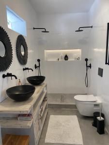 a bathroom with two sinks and a toilet at 3 Paros *All Season* Villas in Parikia