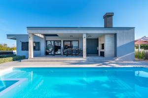 una casa con piscina frente a una casa en Villa Lorena Dalmacija, en Nin