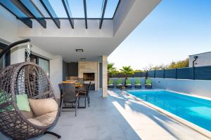 un patio con un columpio junto a una piscina en Villa Lorena Dalmacija, en Nin