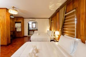 um quarto de hotel com duas camas com lençóis brancos em LuangPrabang Center Hotel em Luang Prabang