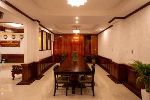 uma sala de jantar com uma mesa de madeira e cadeiras em LuangPrabang Center Hotel em Luang Prabang