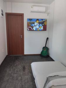 een kamer met een bed, een deur en een gitaar bij Casa contenedor super cómoda in La Floresta