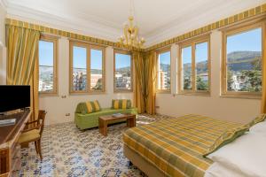 una camera d'albergo con letto, divano e finestre di Hotel Antiche Mura a Sorrento