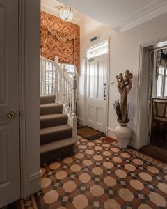 un couloir avec des escaliers et un vase à l'étage dans l'établissement Cranborne House, à Poole