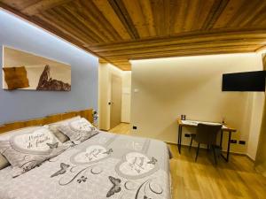 una camera con letto, scrivania e TV di Bed and Breakfast Soffio di Vento a Pont-Saint-Martin