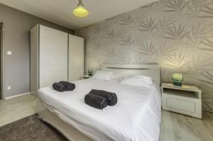 a bedroom with a white bed with two towels on it at Appartement Les Oiseaux in Thionville