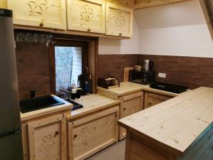 una cocina con armarios de madera y fregadero en Dacza Zakątek, en Falsztyn