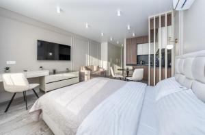 Habitación blanca con cama grande y escritorio. en FlatRent Olympic Park, генератор в будинку, метро поруч!, en Kiev