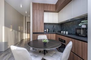 cocina con mesa y sillas blancas en FlatRent Olympic Park, генератор в будинку, метро поруч!, en Kiev