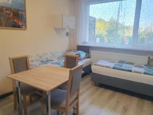 een kamer met 2 bedden en een tafel en stoelen bij Pokoje Babie Lato in Wrocław