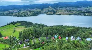 uma vista aérea de uma casa numa colina ao lado de um lago em Dacza Zakątek em Falsztyn